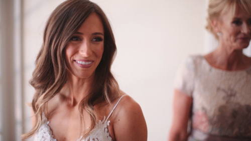 Bride smiling after putting on wedding dress