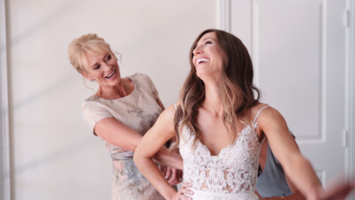 Mom helps very happy bride get into wedding dress Westlake Village Inn