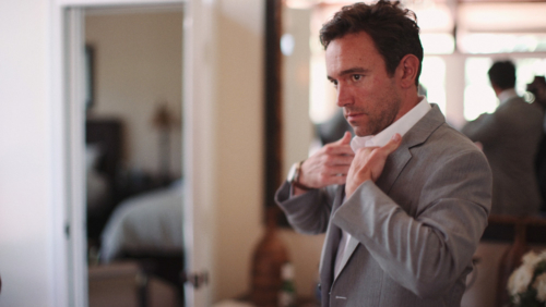 Groomsmen putting on suit before wedding