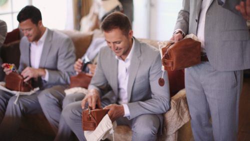 Groomsmen open their customized gifts before wedding