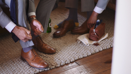 Groomsmen tying shoes before wedding