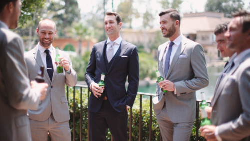 Groom hanging out with groomsmen before wedding drinking beer Stella Artrois