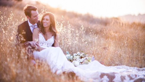 Bride and groom in field with sunlight