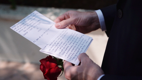 Groom reads card from bride before wedding ceremony