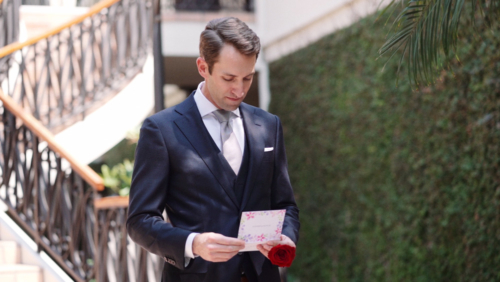 Groom reads heartfelt card from bride before wedding ceremony at first look.