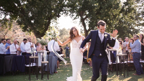 Happy Bride and groom dancing down aisle after wedding ceremony