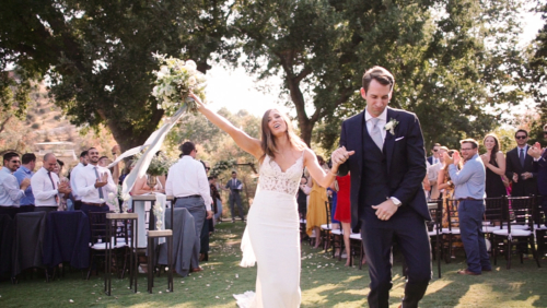 Happy Bride and groom dancing down aisle after wedding ceremony