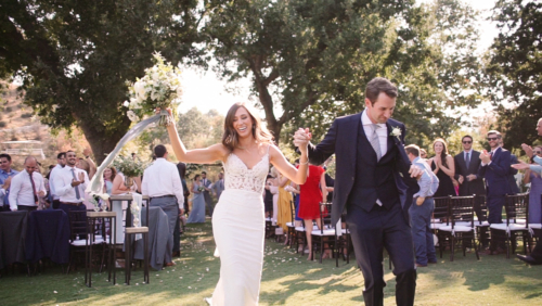 Happy Bride and groom dancing down aisle after wedding ceremony