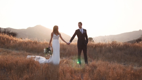 Bride and groom in field with sunlight