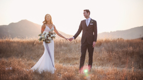 Bride and groom holding hands in field at Brookview Ranch Malibu