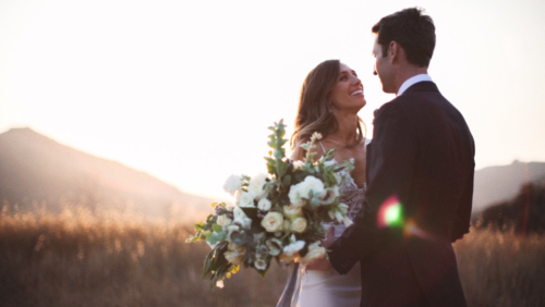 Bride and groom at sunset in field