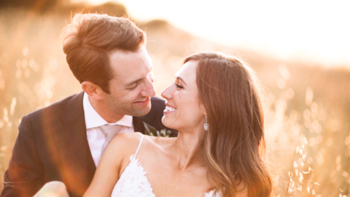 Bride and groom laying in a field at sunset Brookview Ranch Malibu