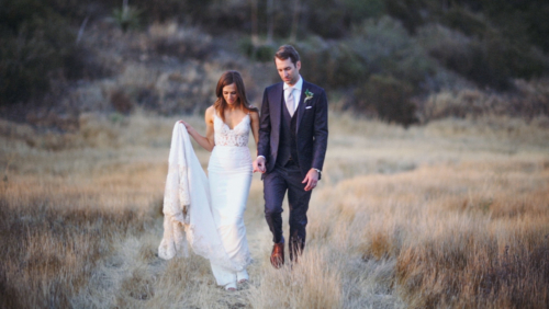 Bride and groom walking in field with sunset Brookview Ranch Malibu