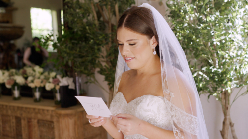 Bride reading card from groom before wedding