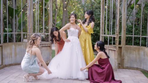 Bride with bridesmaids putting on wedding dress at Botinca Trademark Venue